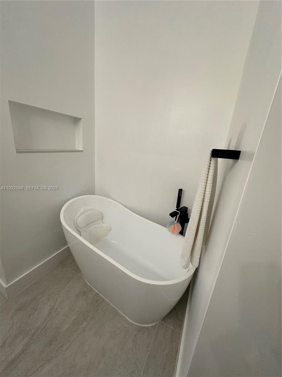 2662 Southwest 118 Road, Unit 2662 Miramar, FL 33025 - Photo 18 of 28 a white bath tub sitting in a bathroom