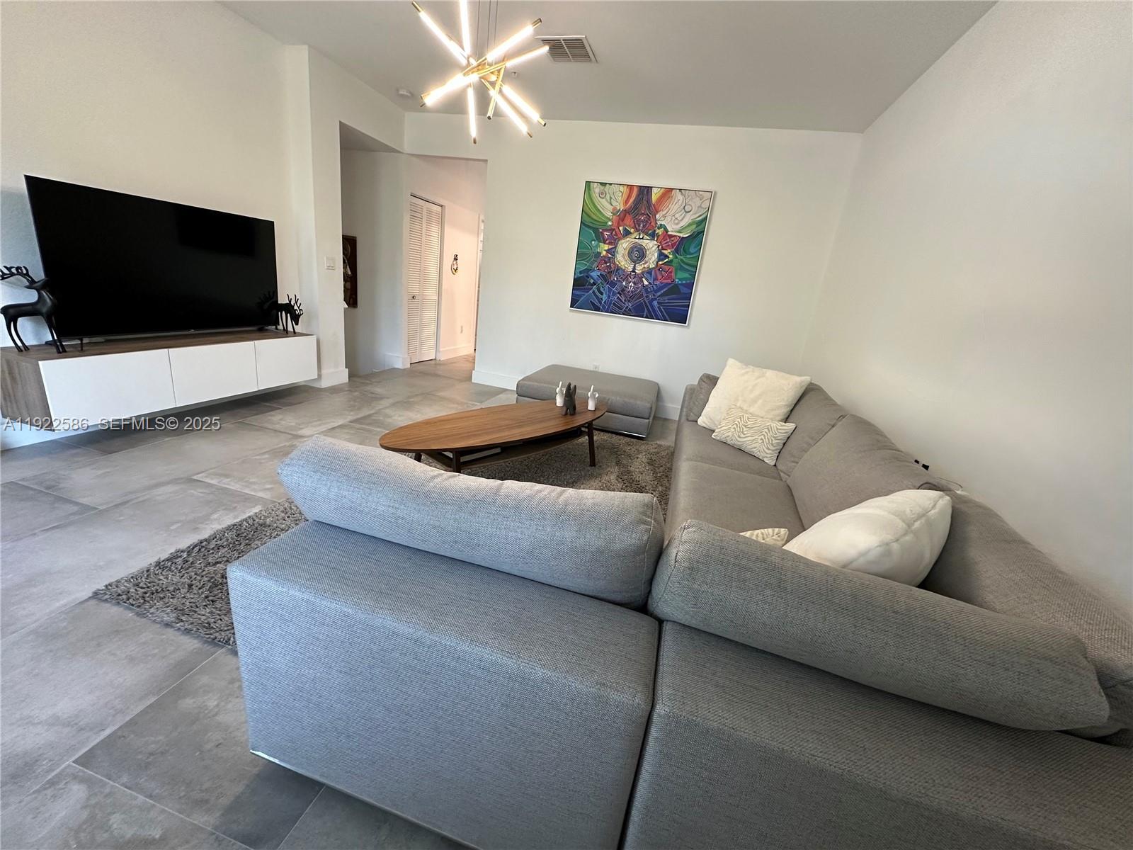 2662 Southwest 118 Road, Unit 2662 Miramar, FL 33025 - Photo 3 of 28 a living room with furniture and a flat screen tv