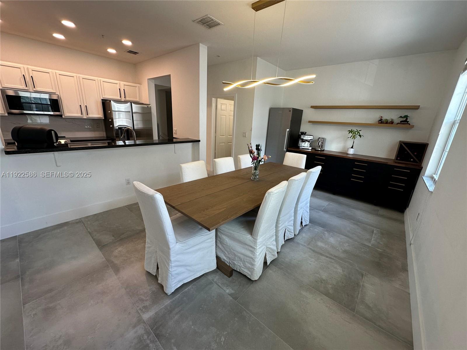 2662 Southwest 118 Road, Unit 2662 Miramar, FL 33025 - Photo 5 of 28 a kitchen with stainless steel appliances kitchen island granite countertop a stove a sink a microwave a refrigerator and cabinets