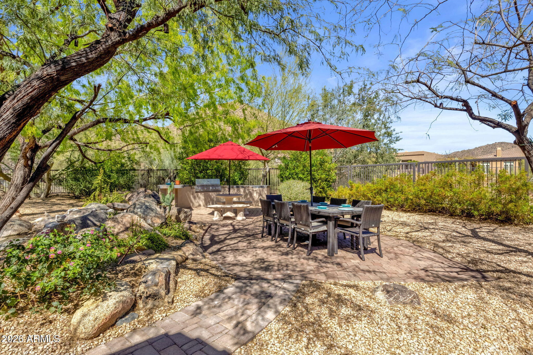 14402 East Wethersfield Road Scottsdale, AZ 85259 - Photo 40 of 57 a view of a patio with chairs and table under an umbrella