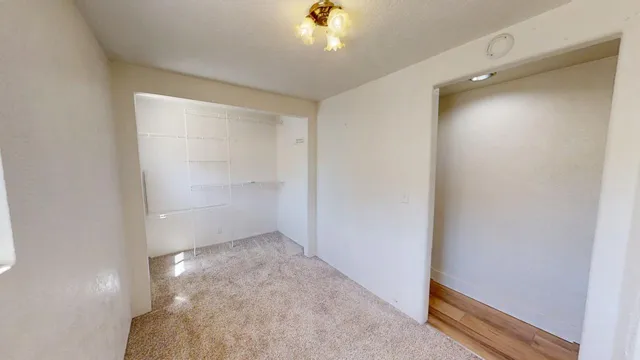 an empty room with a window and a ceiling fan