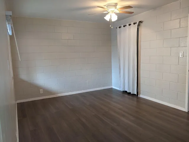 a view of a yard with brick wall and plants