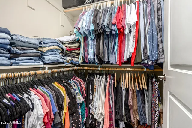 a view of walk in closet with clothes