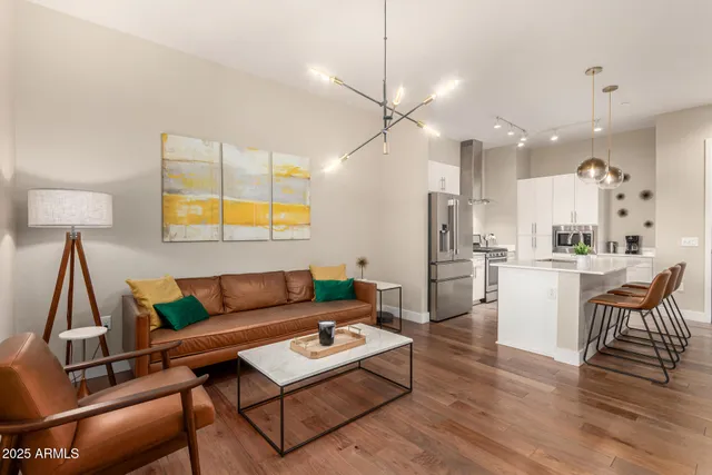 a living room with furniture a wooden floor and a chandelier