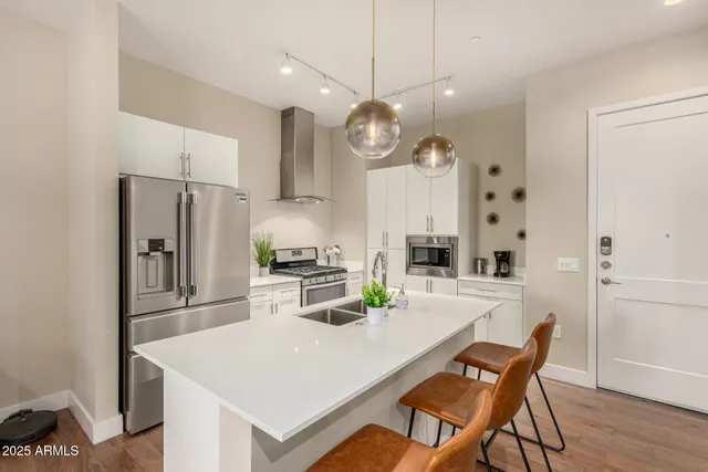 a kitchen with stainless steel appliances a table chairs and chandelier