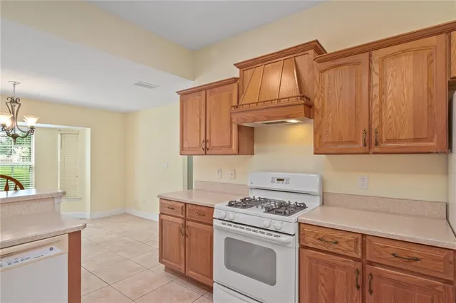 a kitchen with stainless steel appliances granite countertop a sink a stove and a refrigerator with wooden cabinets