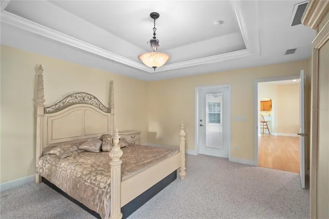a bedroom with a large bed and a chandelier