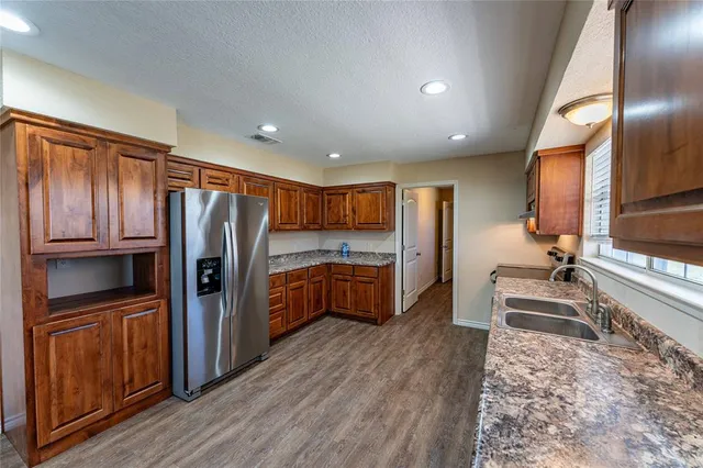 a kitchen with stainless steel appliances granite countertop wooden cabinets and a stove top oven