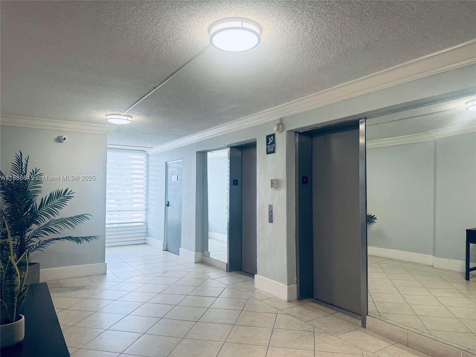 2000 Northeast 135th Street, Unit 403 North Miami, FL 33181 - Photo 17 of 23 Lobby Highlighting Two Elevators