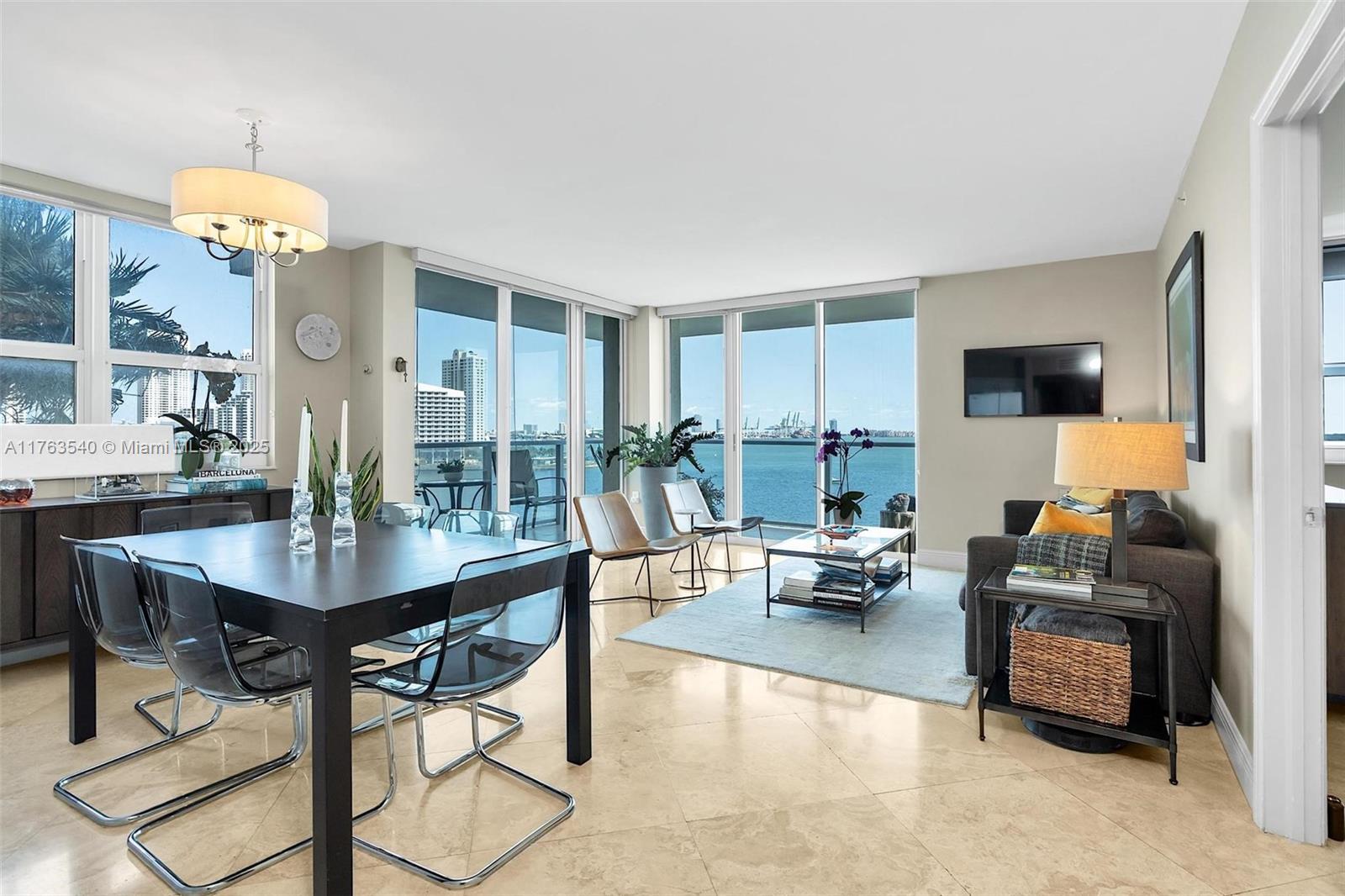 1155 Brickell Bay Drive, Unit 710 Miami, FL 33131 - Photo 16 of 32 a living room with furniture a chandelier and a dining table