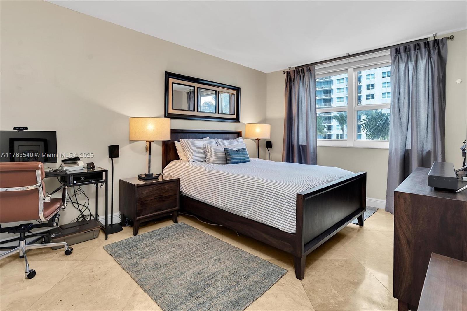 1155 Brickell Bay Drive, Unit 710 Miami, FL 33131 - Photo 21 of 32 a living room with furniture a lamp and a flat screen tv