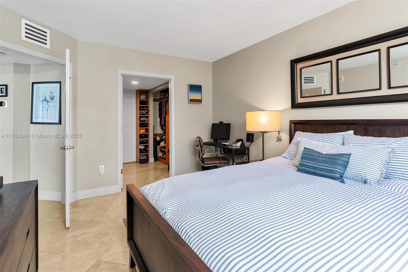 1155 Brickell Bay Drive, Unit 710 Miami, FL 33131 - Photo 22 of 32 a bedroom with a bed and a chandelier