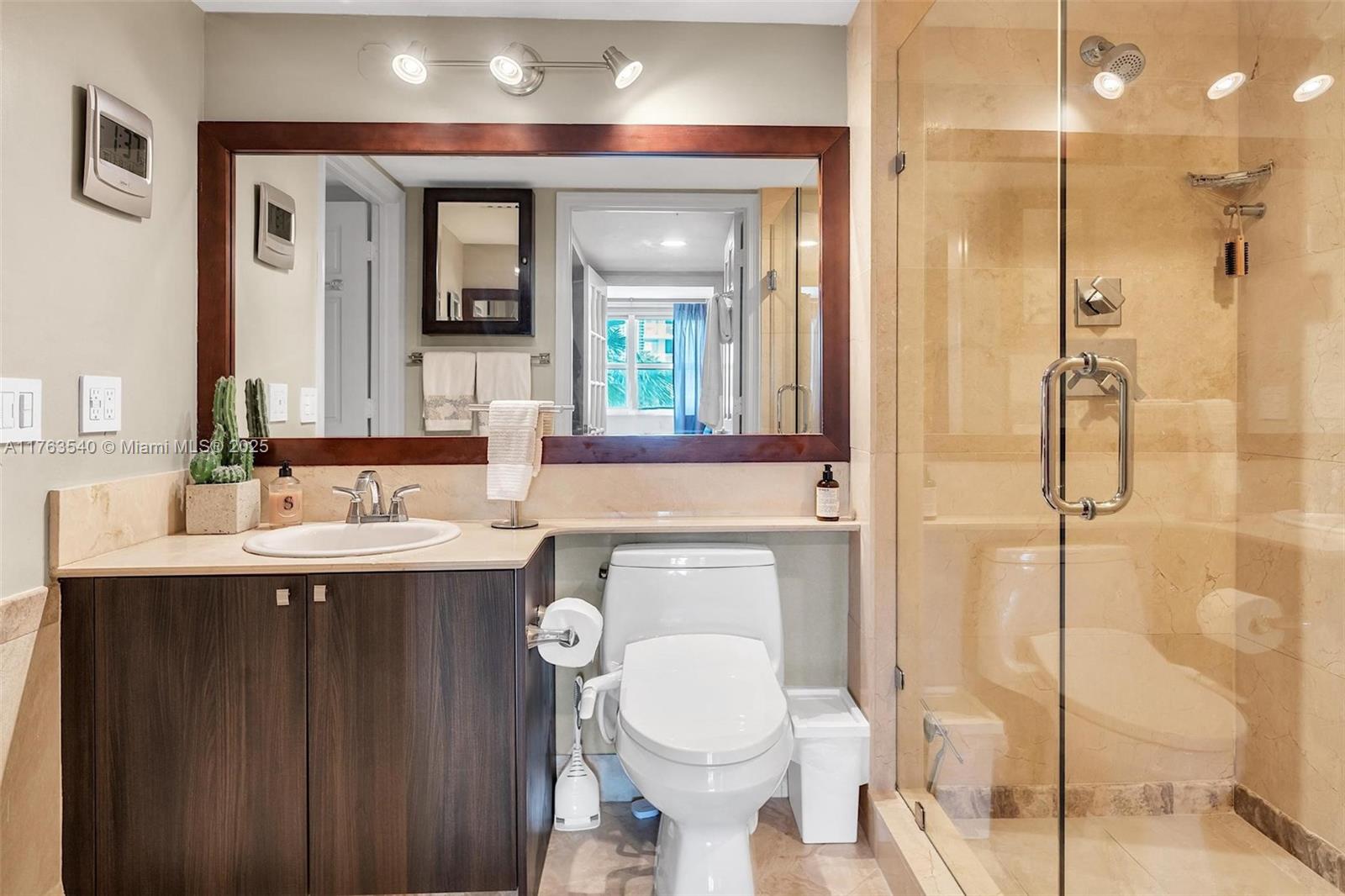 1155 Brickell Bay Drive, Unit 710 Miami, FL 33131 - Photo 23 of 32 a bathroom with a toilet sink and mirror