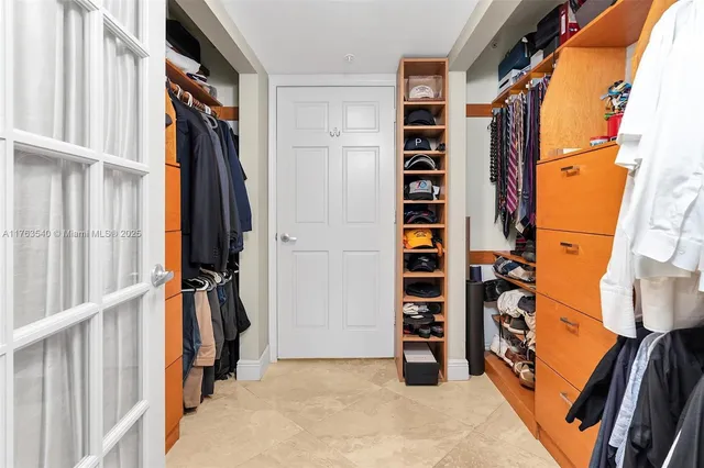 a view of walk in closet with clothes and shoes