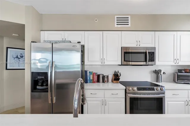 a kitchen with stainless steel appliances a refrigerator stove and microwave