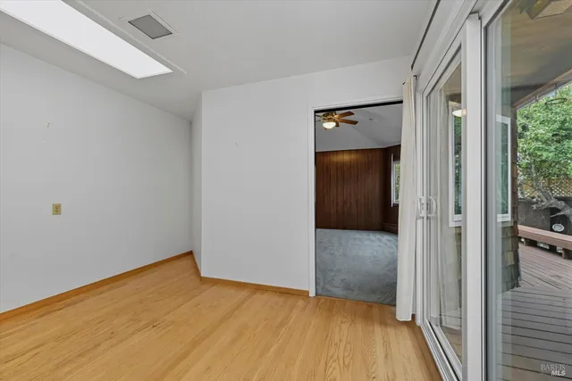 a view of a hallway with wooden floor and a bathroom