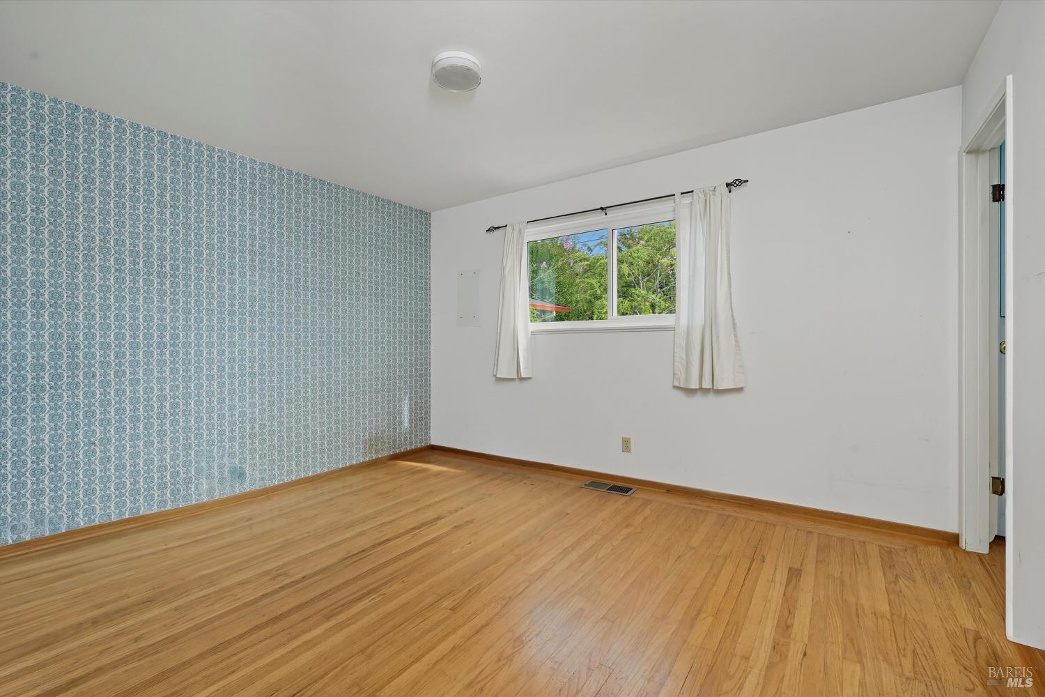 3735 Sacramento Avenue Santa Rosa, CA 95405 - Photo 15 of 24 a view of an empty room with wooden floor and a window