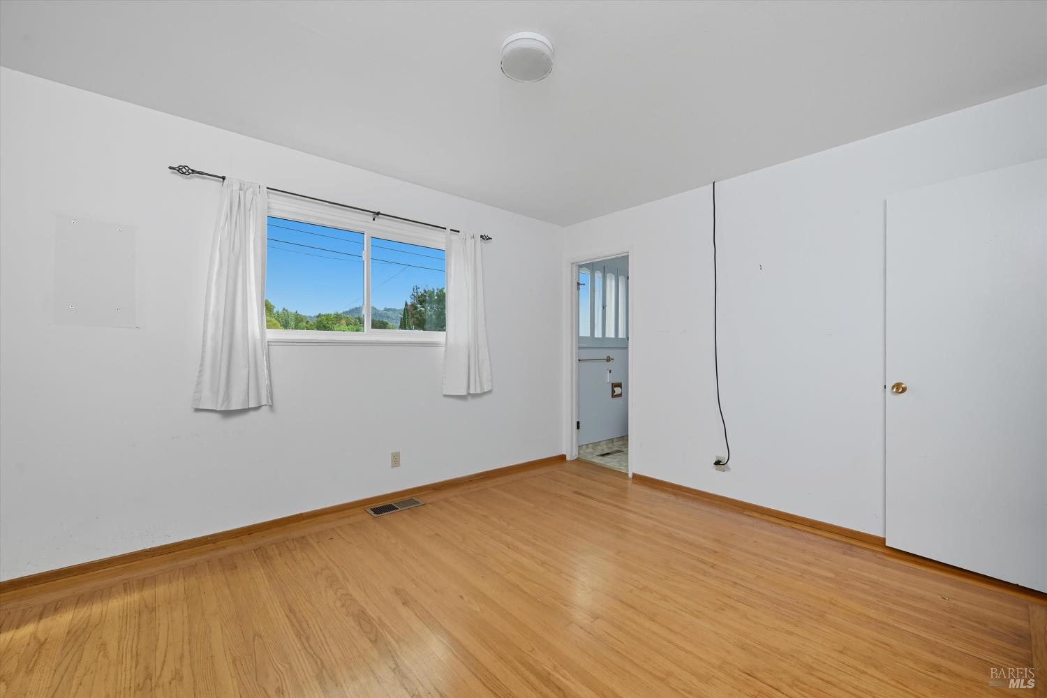 3735 Sacramento Avenue Santa Rosa, CA 95405 - Photo 16 of 24 a view of an empty room with wooden floor and a window