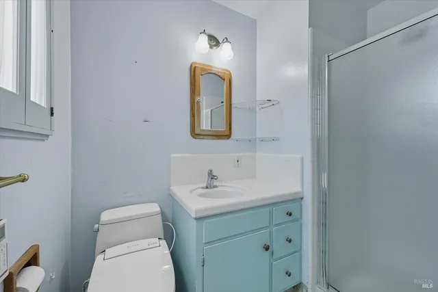 a bathroom with a toilet sink vanity and mirror