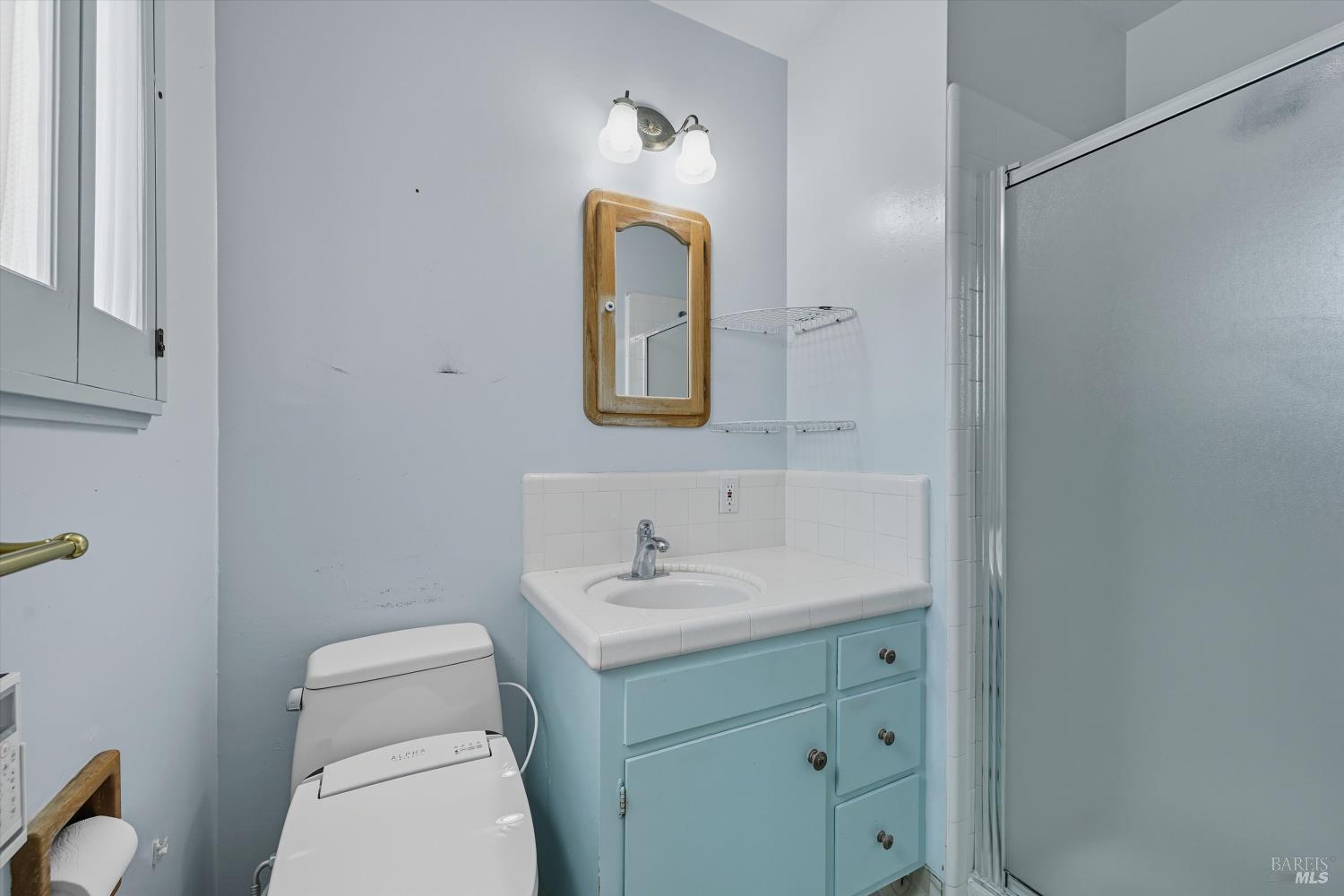 3735 Sacramento Avenue Santa Rosa, CA 95405 - Photo 19 of 24 a bathroom with a toilet sink vanity and mirror