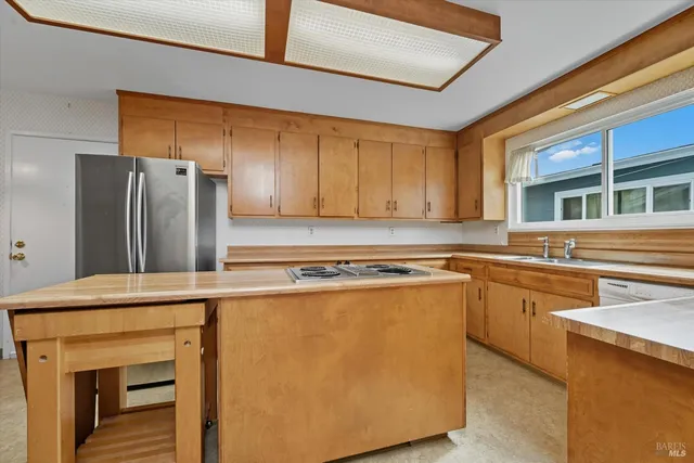 a kitchen with stainless steel appliances granite countertop a refrigerator and a stove top oven