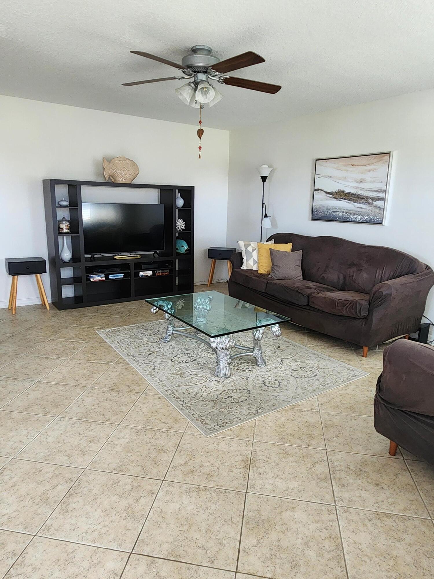 148 Tuscany Lane, Unit B Delray Beach, FL 33446 - Photo 5 of 11 a living room with furniture and a flat screen tv