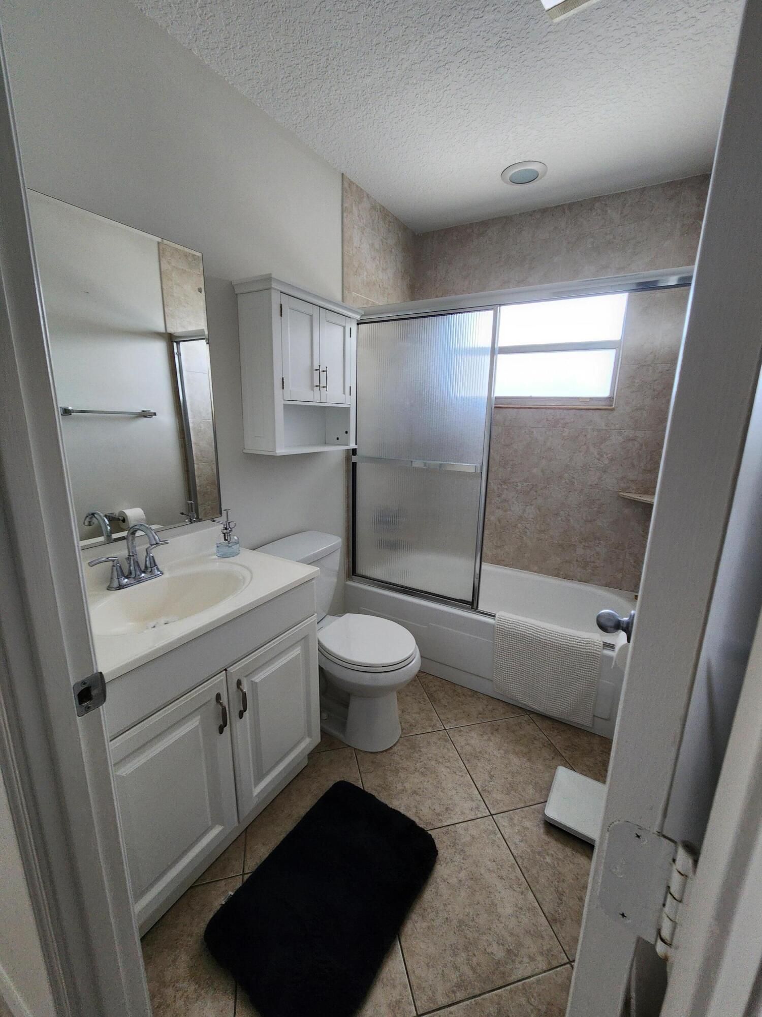 148 Tuscany Lane, Unit B Delray Beach, FL 33446 - Photo 9 of 11 a bathroom with a sink toilet and shower