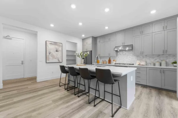a kitchen with kitchen island granite countertop a sink cabinets and wooden floor