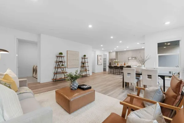 a living room with furniture kitchen view and a large window