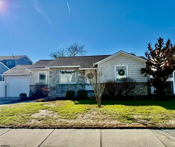 a front view of a house with a yard and potted plants