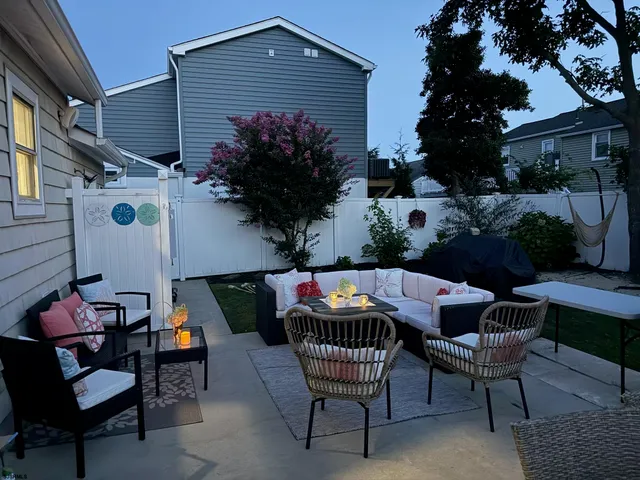 a patio with tables and chairs potted plants