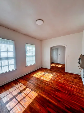 a view of empty room with window and wooden floor