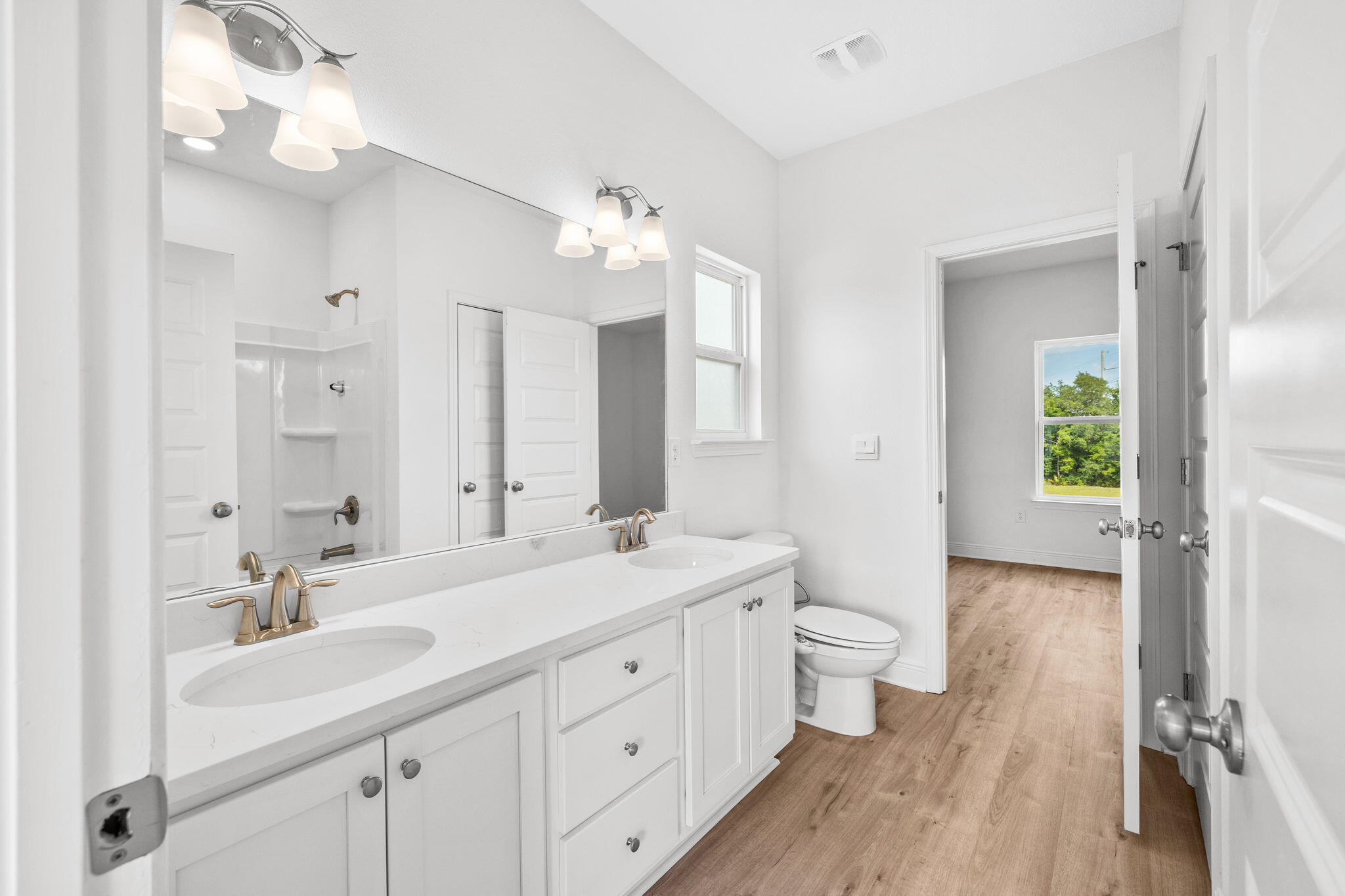 100 JRS Way Santa Rosa Beach, FL 32459 - Photo 24 of 74 a spacious bathroom with a double vanity sink a large mirror a toilet and a shower