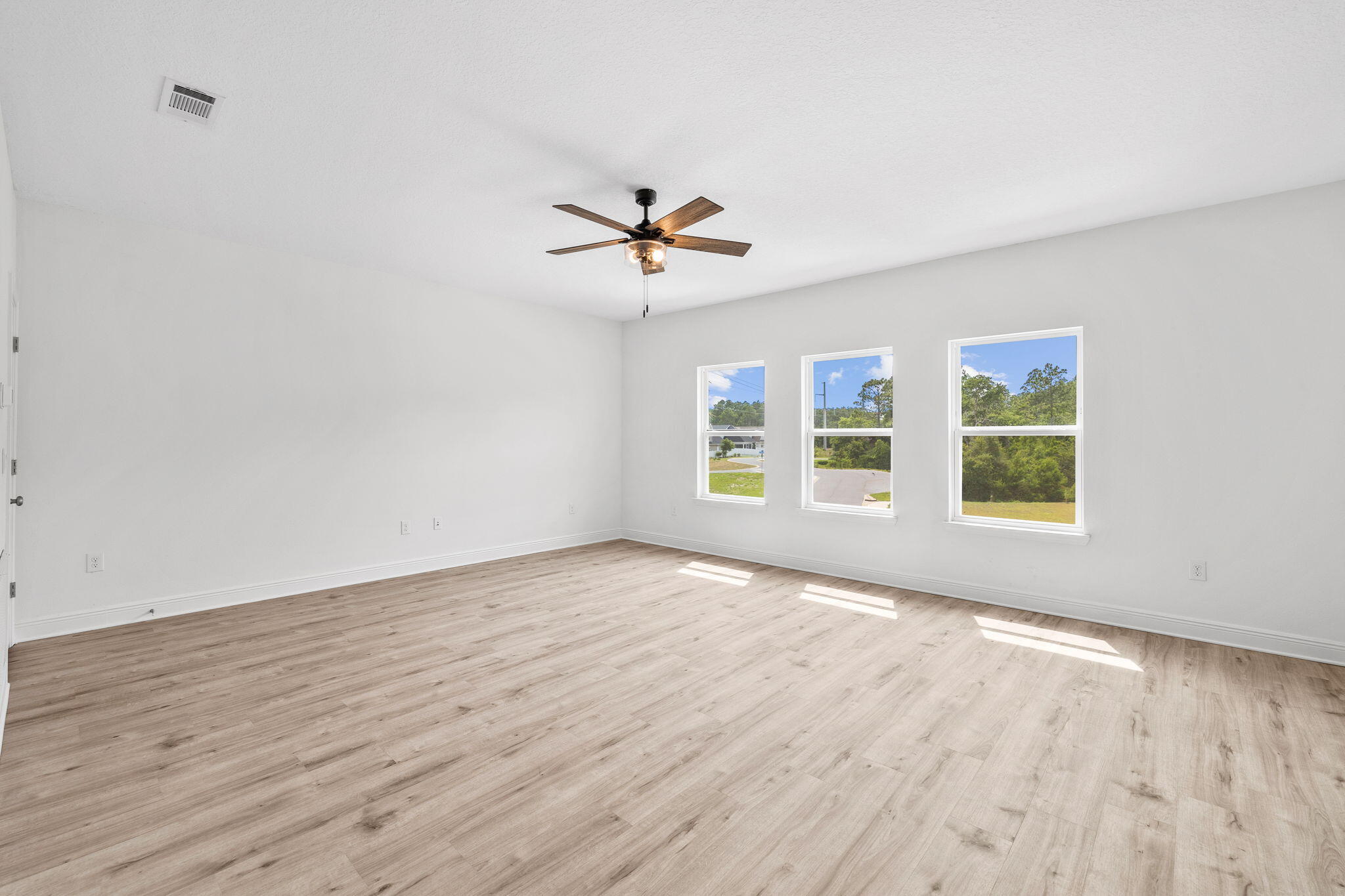 100 JRS Way Santa Rosa Beach, FL 32459 - Photo 33 of 74 an empty room with wooden floor ceiling fan and windows