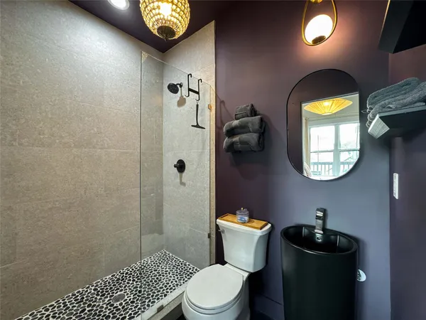 a bathroom with a toilet sink vanity and mirror