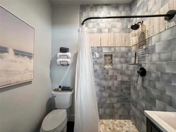 a bathroom with a toilet and a shower