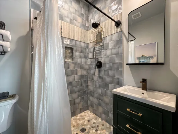 a bathroom with a sink a toilet and shower