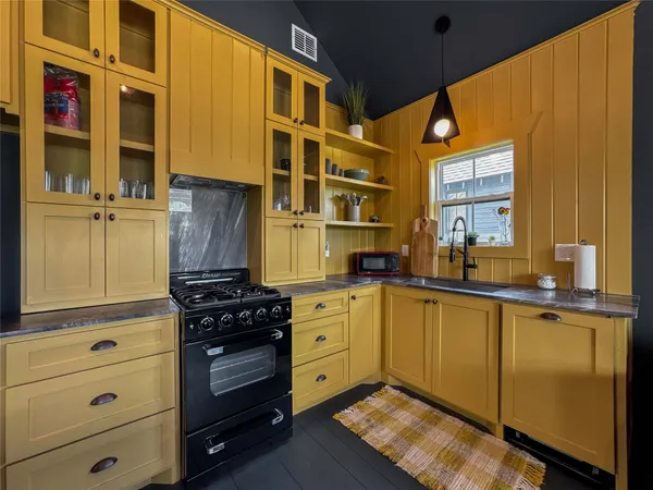 a kitchen with stainless steel appliances granite countertop a stove and cabinets