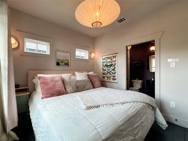 a bedroom with a large bed and a mirror