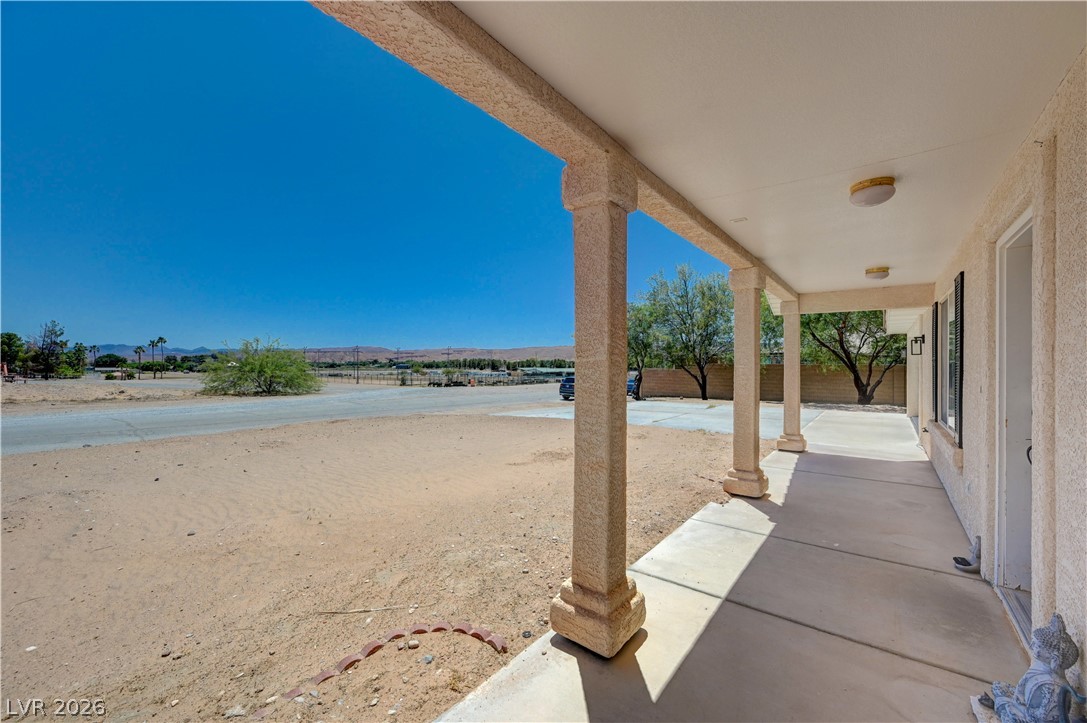 1272 Liston Avenue Logandale, NV 89021 - Photo 7 of 61 A welcoming covered porch with sturdy pillars provides shade and expansive views of the surrounding landscape.