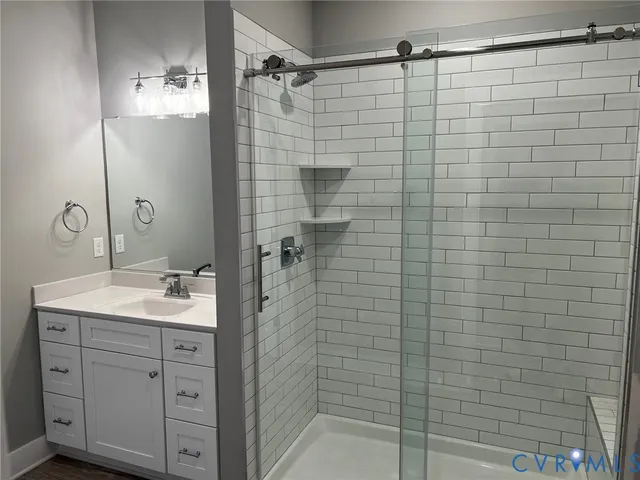 a bathroom with a shower sink and mirror