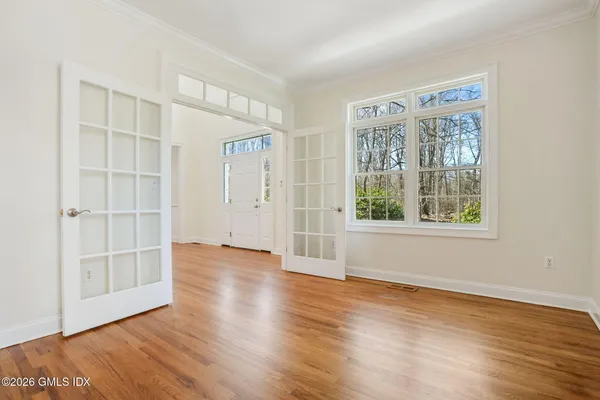 an empty room with wooden floor and windows