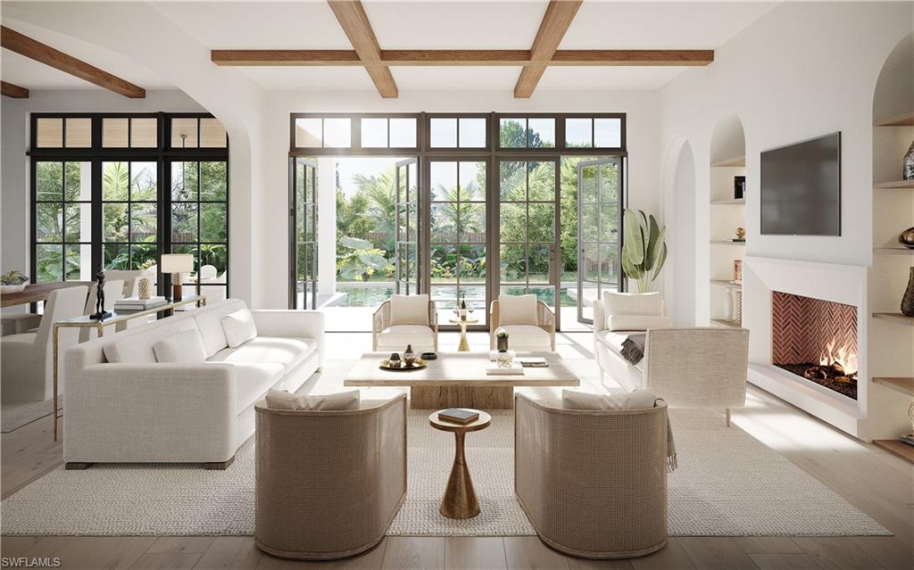 3880 Crayton Road Naples, FL 34103 - Photo 2 of 13 a living room with couches a flat screen tv and a fireplace