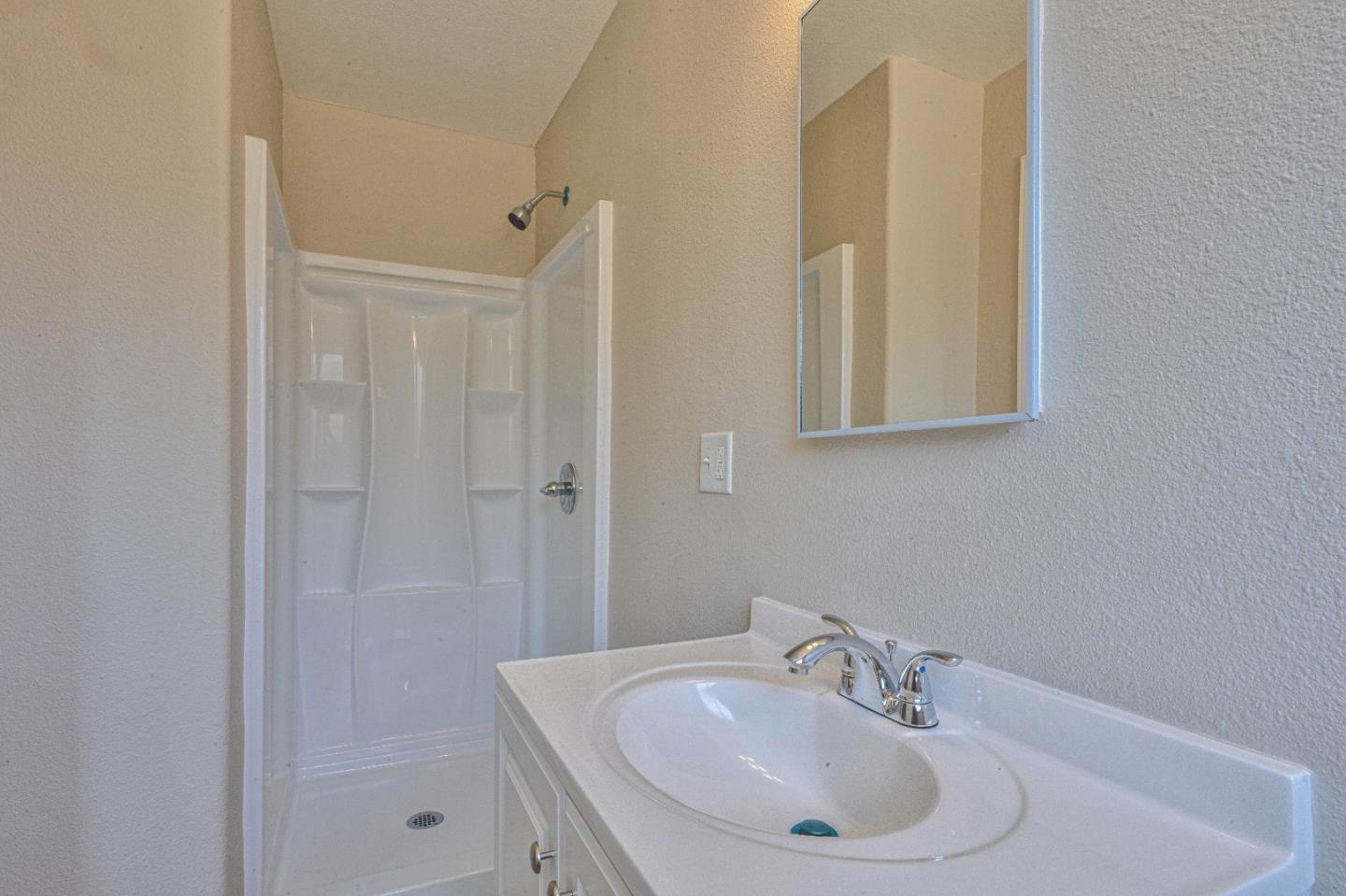 104 Inca Drive Soledad, CA 93960 - Photo 17 of 28 a bathroom with a sink a shower and a mirror