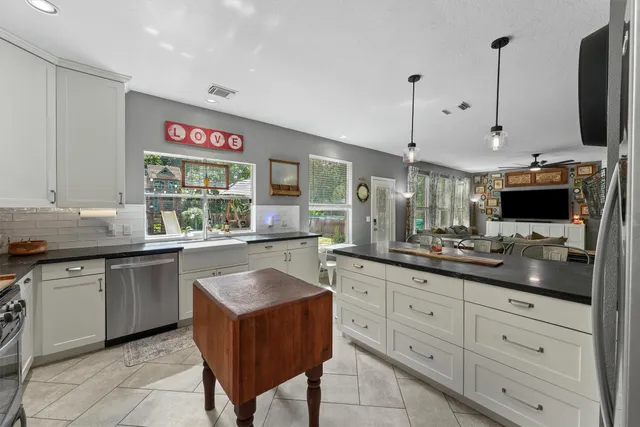 a kitchen with stainless steel appliances granite countertop a refrigerator a stove a sink and a microwave