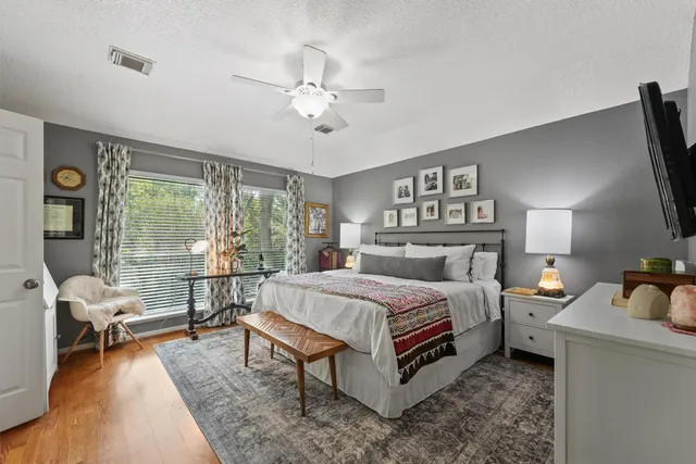 a bedroom with a bed and a flat tv screen on dresser