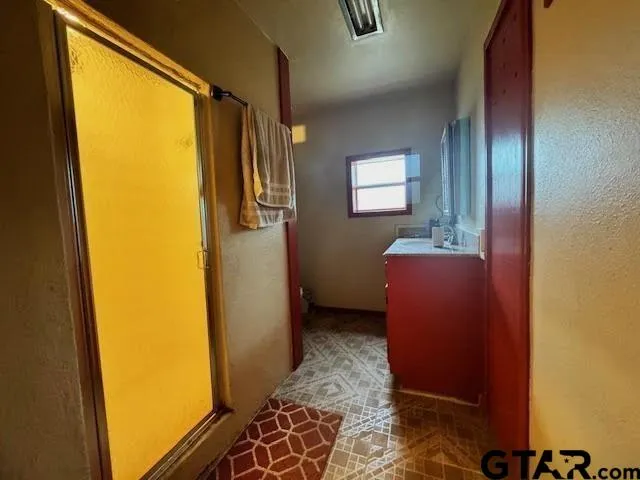 a bathroom with a sink mirror and shower