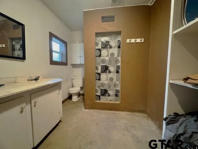 a bathroom with a sink and mirror with toilet