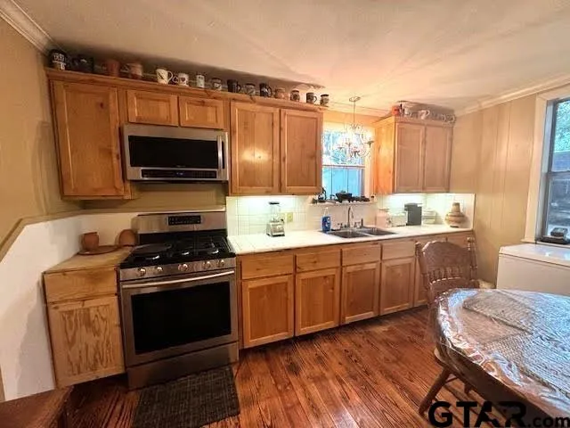 a kitchen with a stove a sink and a microwave
