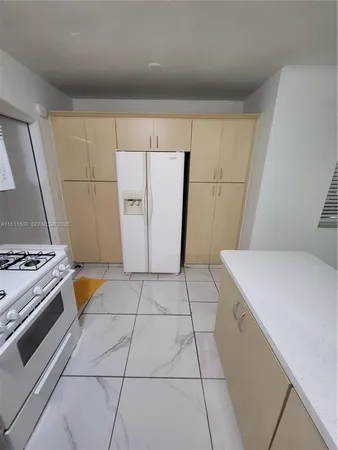 a kitchen with kitchen island cabinets a sink stove and refrigerator
